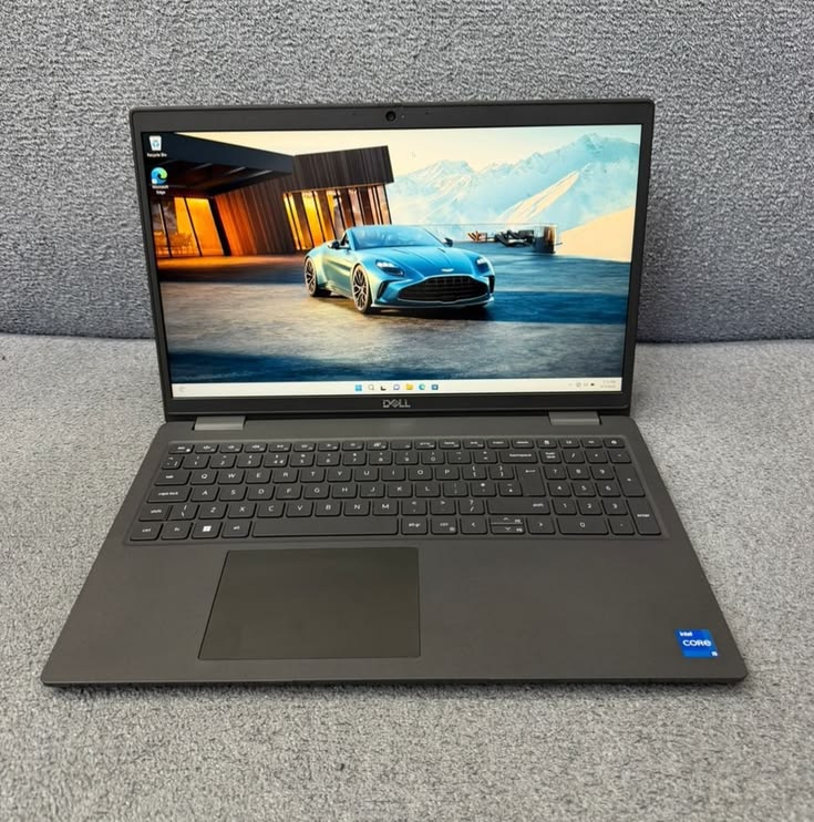 Dell Latitude 15-inch open showing Windows 11 with sports car wallpaper - Intel Core i5 badge visible