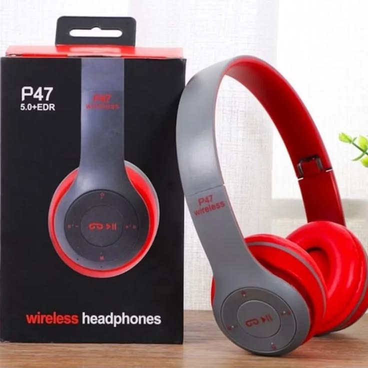 P47 wireless Bluetooth headphones red and gray color with original black box on wooden surface with plant in background