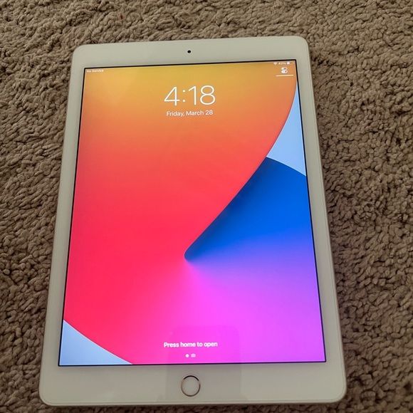 Apple iPad Air 1st Generation front view showing iOS 14 colorful wallpaper with home button - Silver