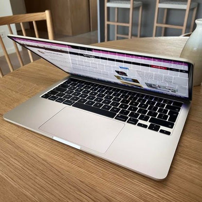 MacBook Pro M1 open showing macOS with lake wallpaper